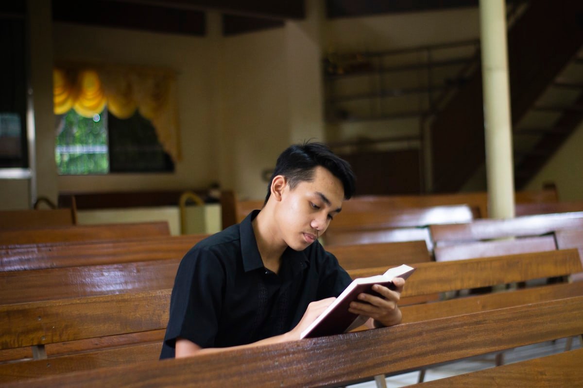 Young Filipino man reading quietly in a church pew