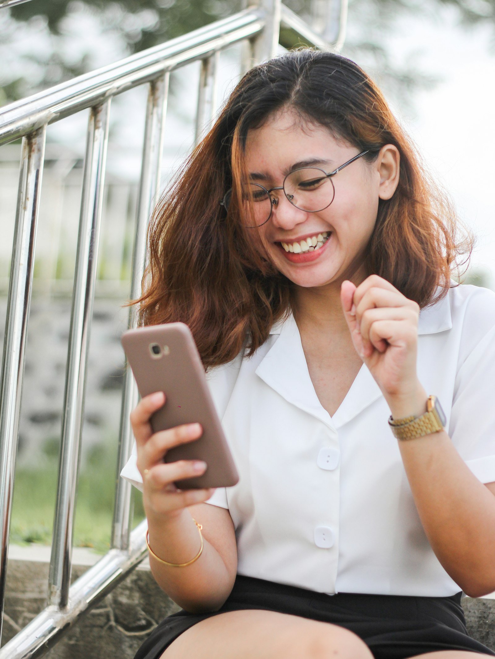 A Filipina customer in a white blouse booking on her smartphone — the self-service way to reserve a slot at a small business without the Messenger back-and-forth