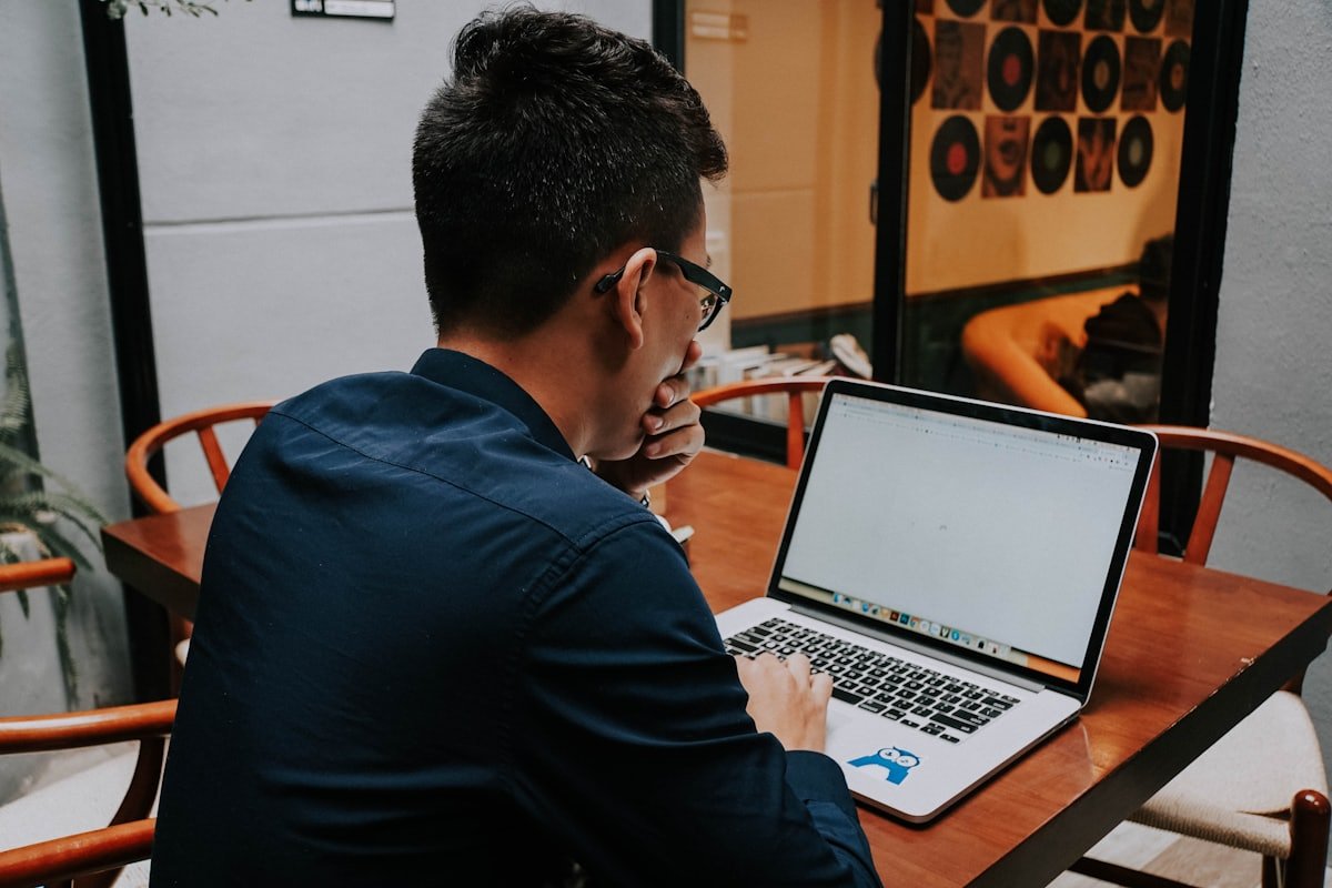 Asian entrepreneur working focused on a laptop at a cafe table